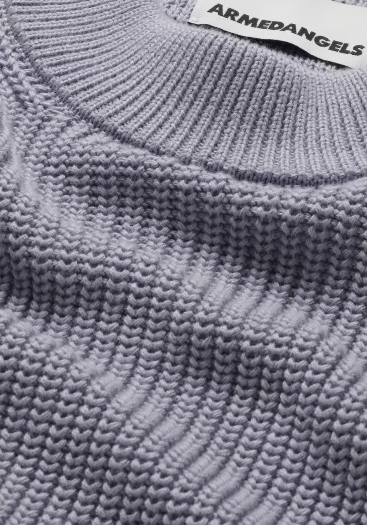 Nahaufnahme des feinen, rippigen Stoffmusters des HAAYLE Sweaters in „misty morning“. Der extra weiche Heavy Knit aus Bio-Baumwolle überzeugt durch seine strukturierte Oberfläche.