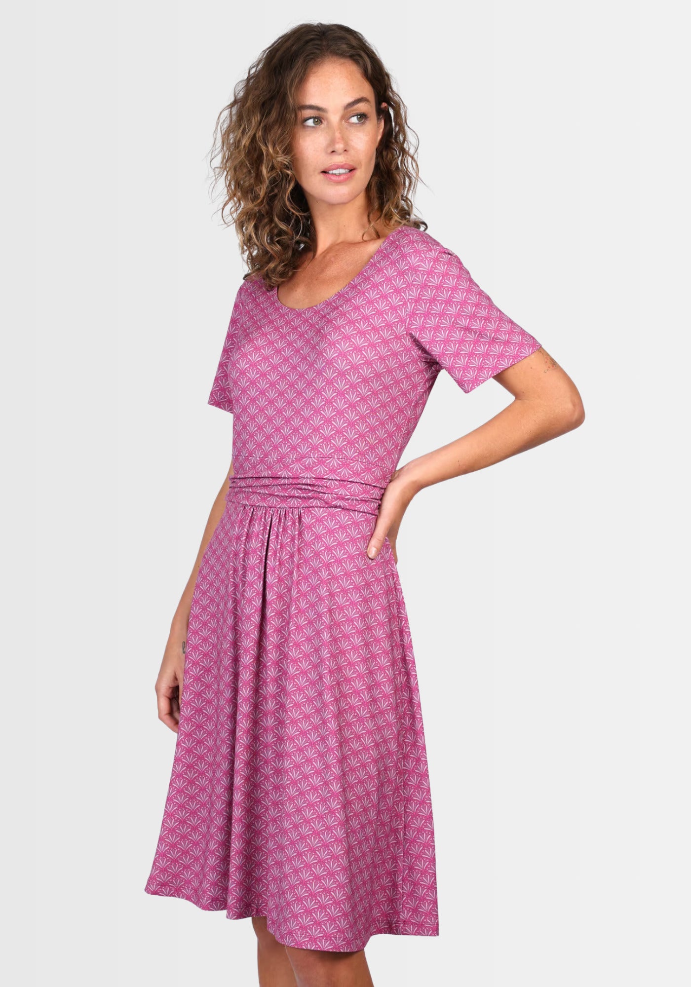 Seitenansicht des Kleids „Malindamia“ in kräftigem Himbeerrot. Das lässige Design mit Eingrifftaschen an den Seiten und der schwingende Rock verleihen eine verspielte Note, perfekt für warme Tage.