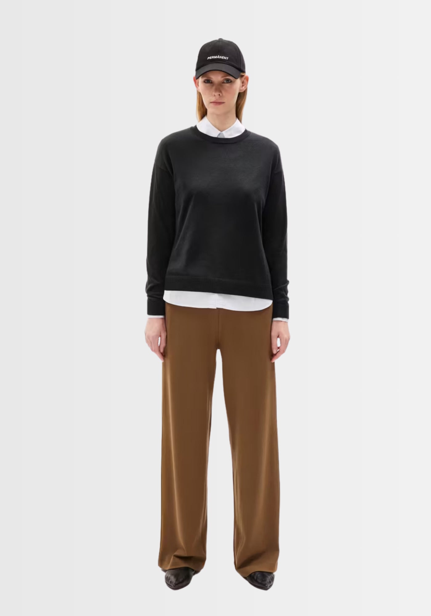 Vorderansicht des Larunaa Pullovers in Schwarz, zeigt die bequeme, leicht kastige Passform und den klassischen Rundhalsausschnitt.