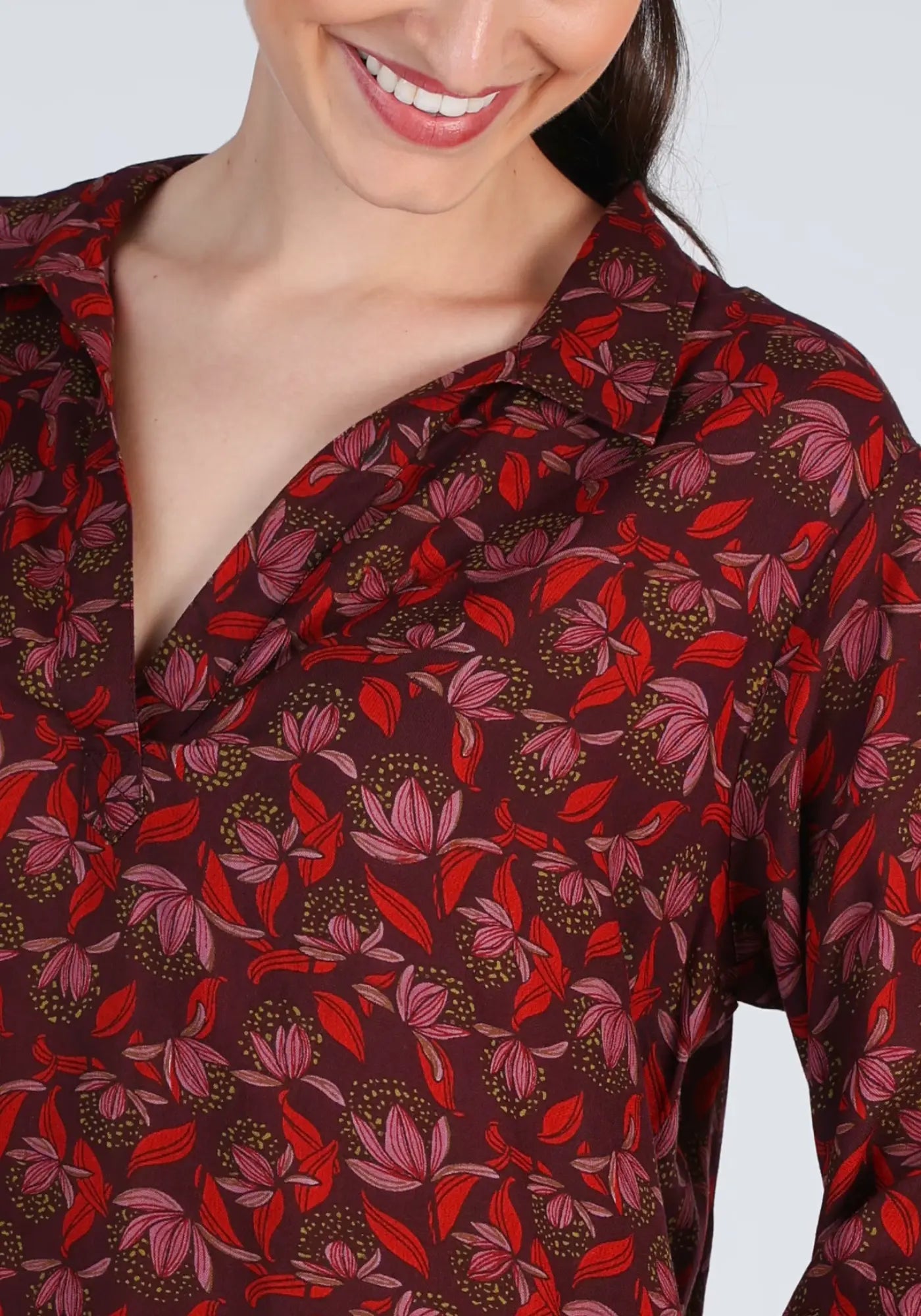 Die luftige Magda Tunika in Rot besticht durch ihren floralen Print und den bequemen Hemdblusenkragen. Ein ideales Kleidungsstück für den Übergang in die kühleren Monate.