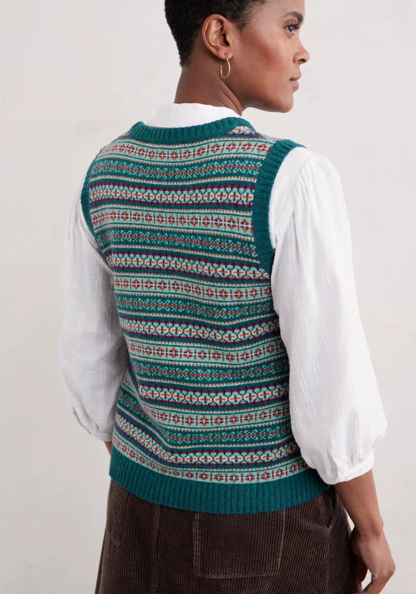 Die Percella Weste in Grün besticht durch ihr geometrisches Muster und einen weichen Merino-Mix. Perfekt, um deiner Herbst- und Wintergarderobe einen Hauch von Farbe und Stil zu verleihen.