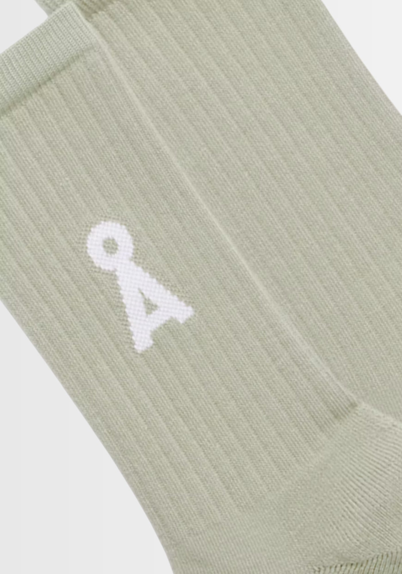 Nahaufnahme der SAAMUS BOLD Socken in „seagreen“, gefertigt aus 78% Bio-Baumwolle, 20% recyceltem Polyamid und 2% Elasthan. Das auffällige A‑Logo unterstreicht den modernen Look, während GOTS-Zertifizierung und PETA-approved vegan für nachhaltige Qualität stehen.
