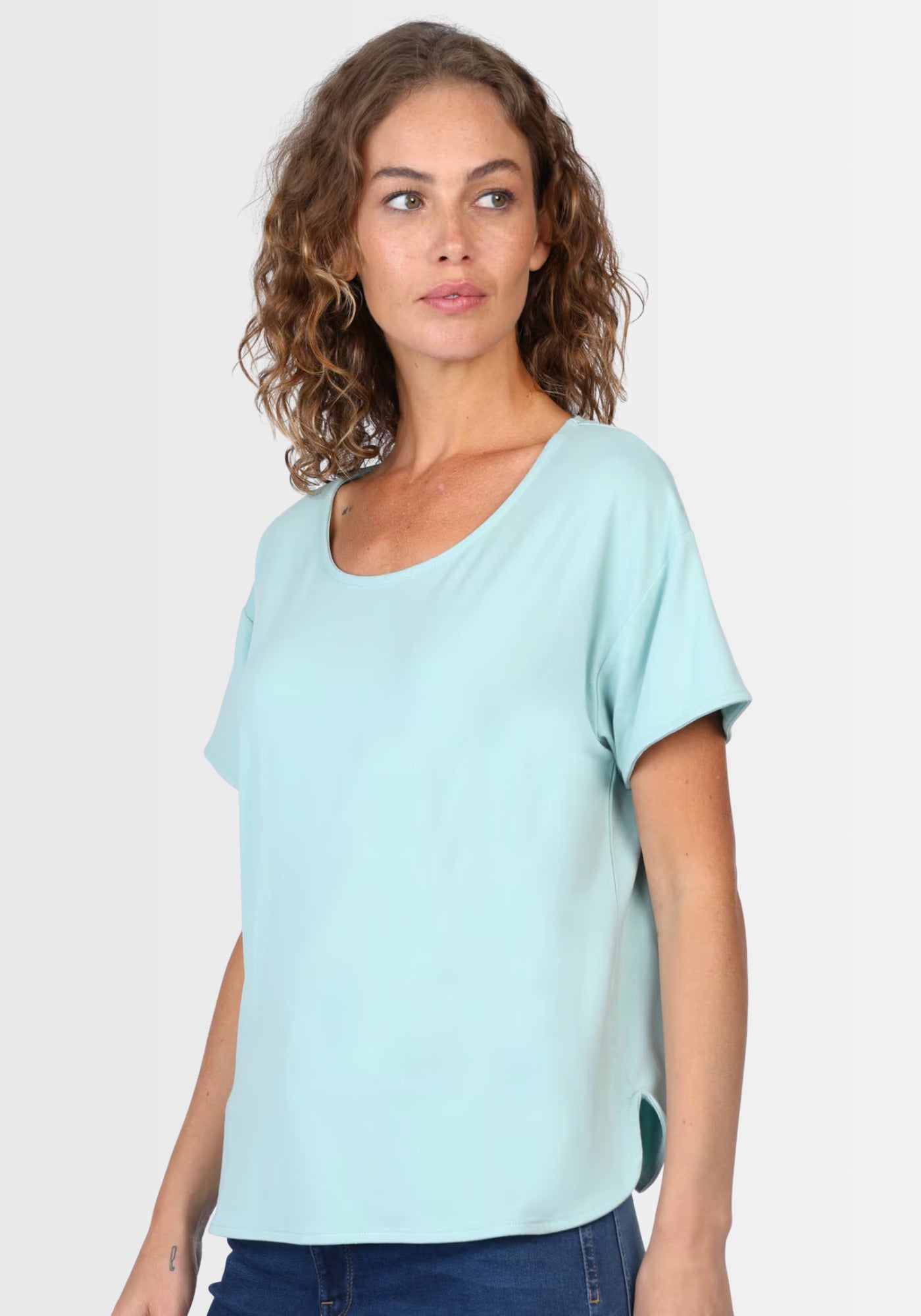 Seitenansicht des T-Shirts "Betzi" in Turquoise, die den lockeren Schnitt und die kurzen Ärmel hervorhebt – perfekt kombinierbar mit Jeans oder Rock für einen entspannten Alltagslook.