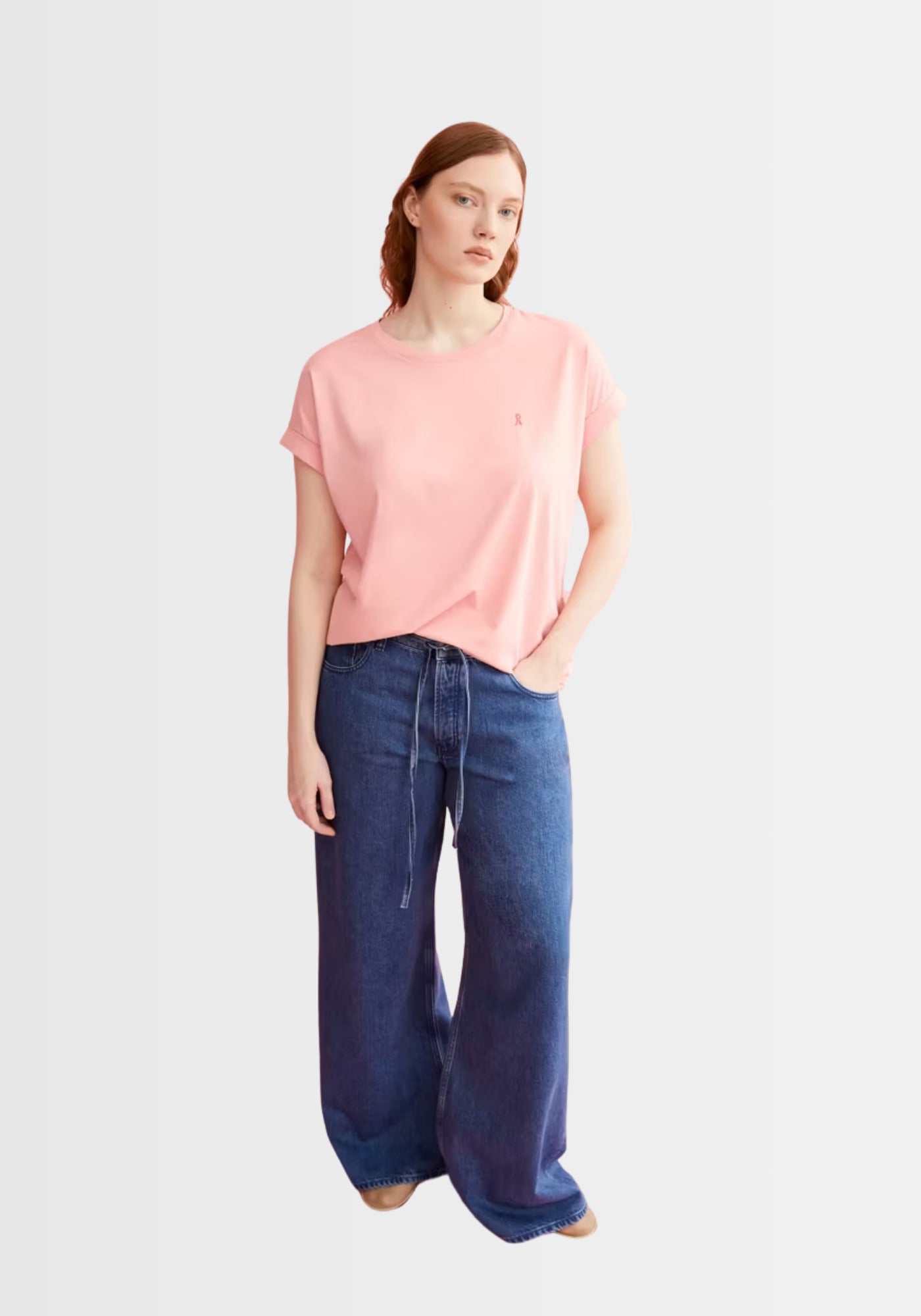 Model trägt das locker geschnittene Idaara T-Shirt in zartem Rosa (deep rosalilly), kombiniert mit einer weiten Jeanshose für einen modernen Casual-Style.
