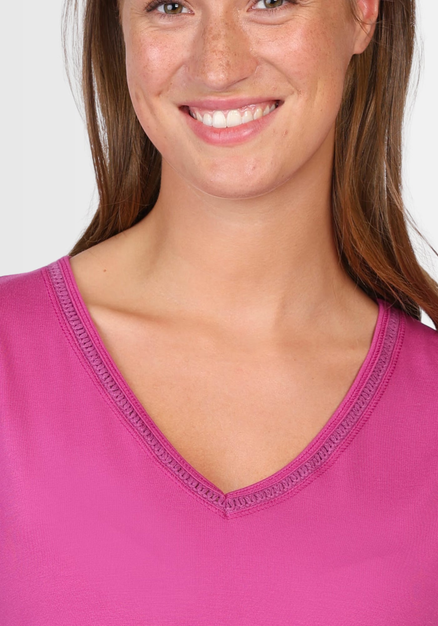 Nahaufnahme des eleganten V-Ausschnitts des T-Shirts "Nylara" in leuchtendem Raspberry. Die feine Verarbeitung des nachhaltigen Materials sorgt für einen weichen und luftigen Tragekomfort.
