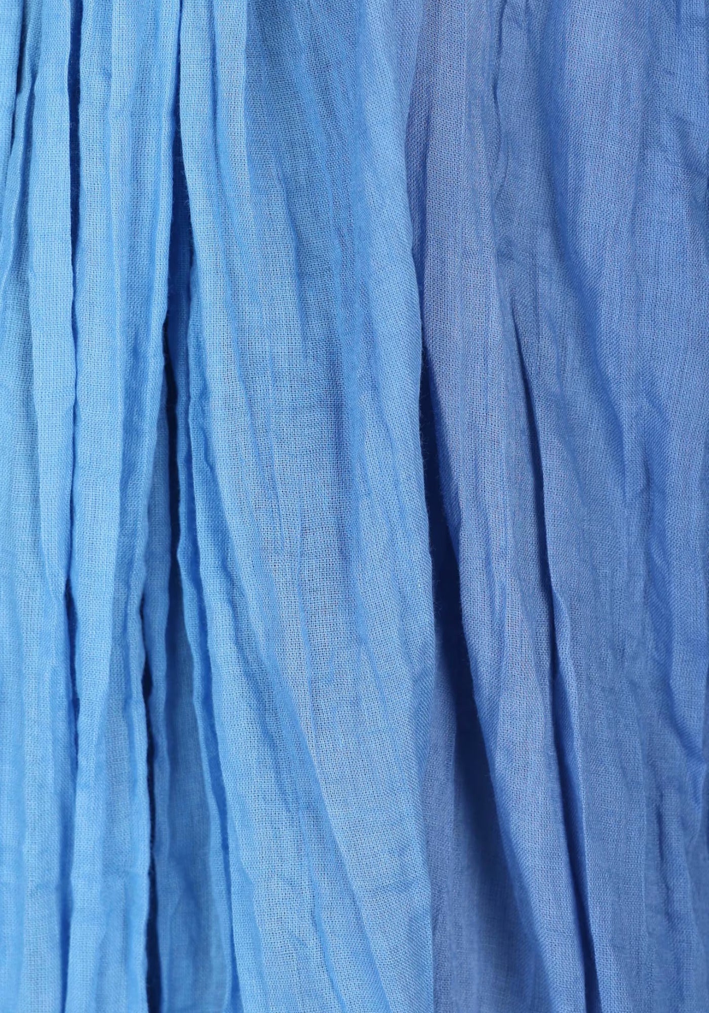 Nahaufnahme des Tuchs „Asta“, zeigt den harmonischen Farbverlauf in verschiedenen Blautönen. Das weiche Gewebe aus 100% Baumwolle ist hautfreundlich und pflegeleicht.