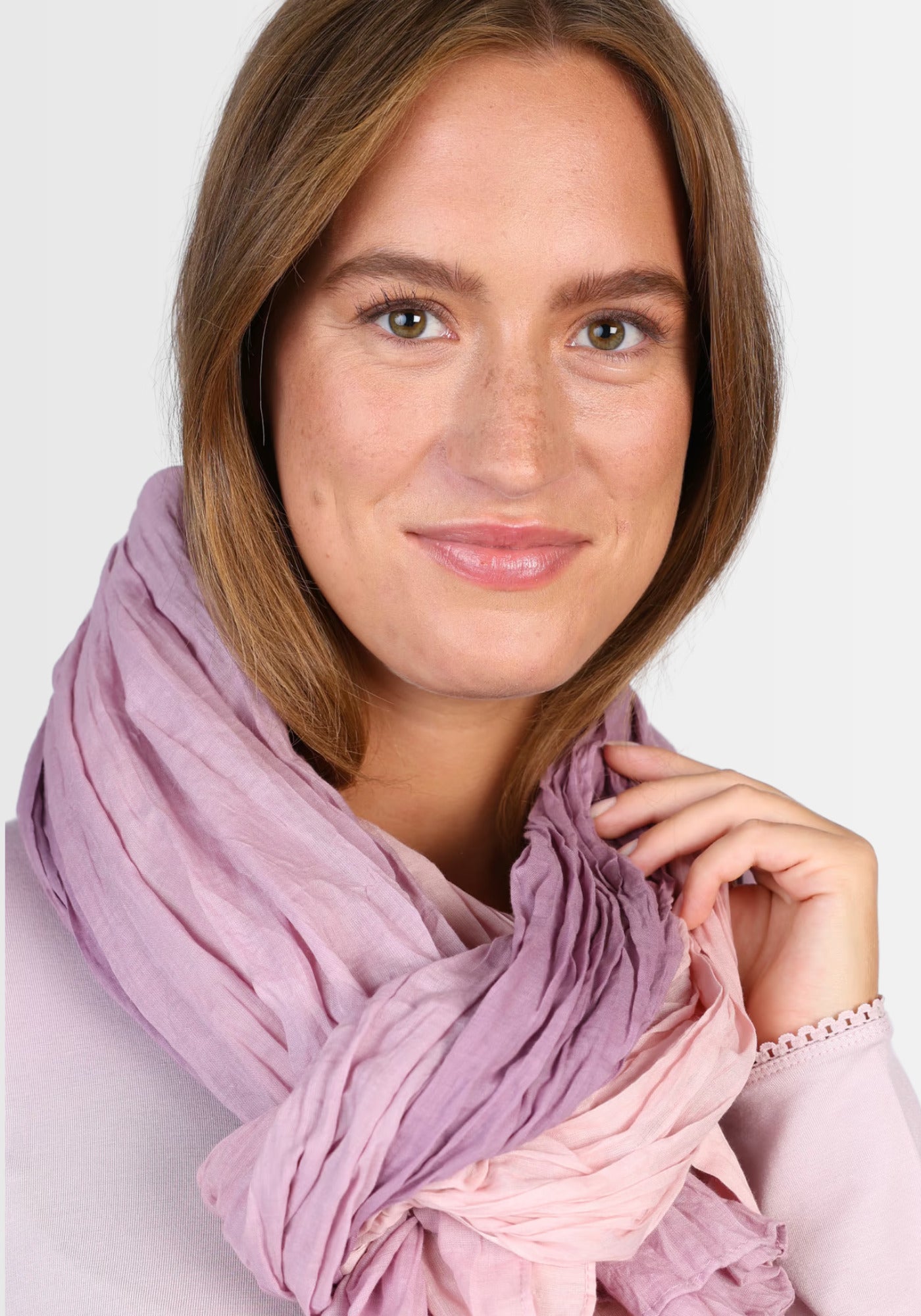 Ein Model trägt den Tuch „Asta – Lavender“ als elegantes Accessoire. Die weiche Bio-Baumwolle und der fließende Farbverlauf in zarten Lavendel- und Blautönen verleihen jedem Outfit einen femininen Touch.
