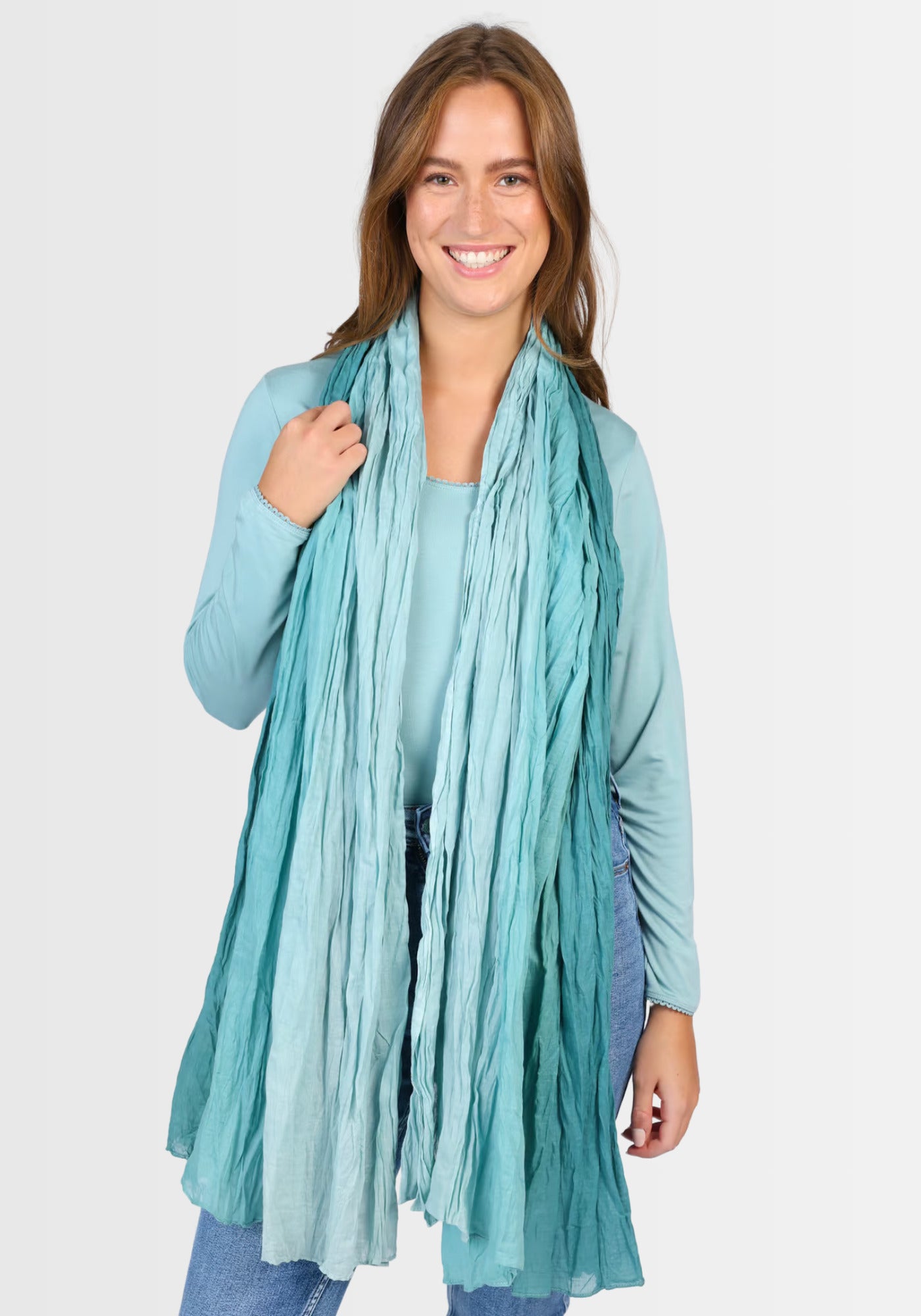 Lifestyle-Aufnahme des Tuchs „Asta – Mermaid“ in Blau, getragen als modisches Accessoire in einem urbanen Outfit. Die weiche Baumwollqualität und der elegante, meerjungfraueninspirierte Farbverlauf machen es zum echten Hingucker.