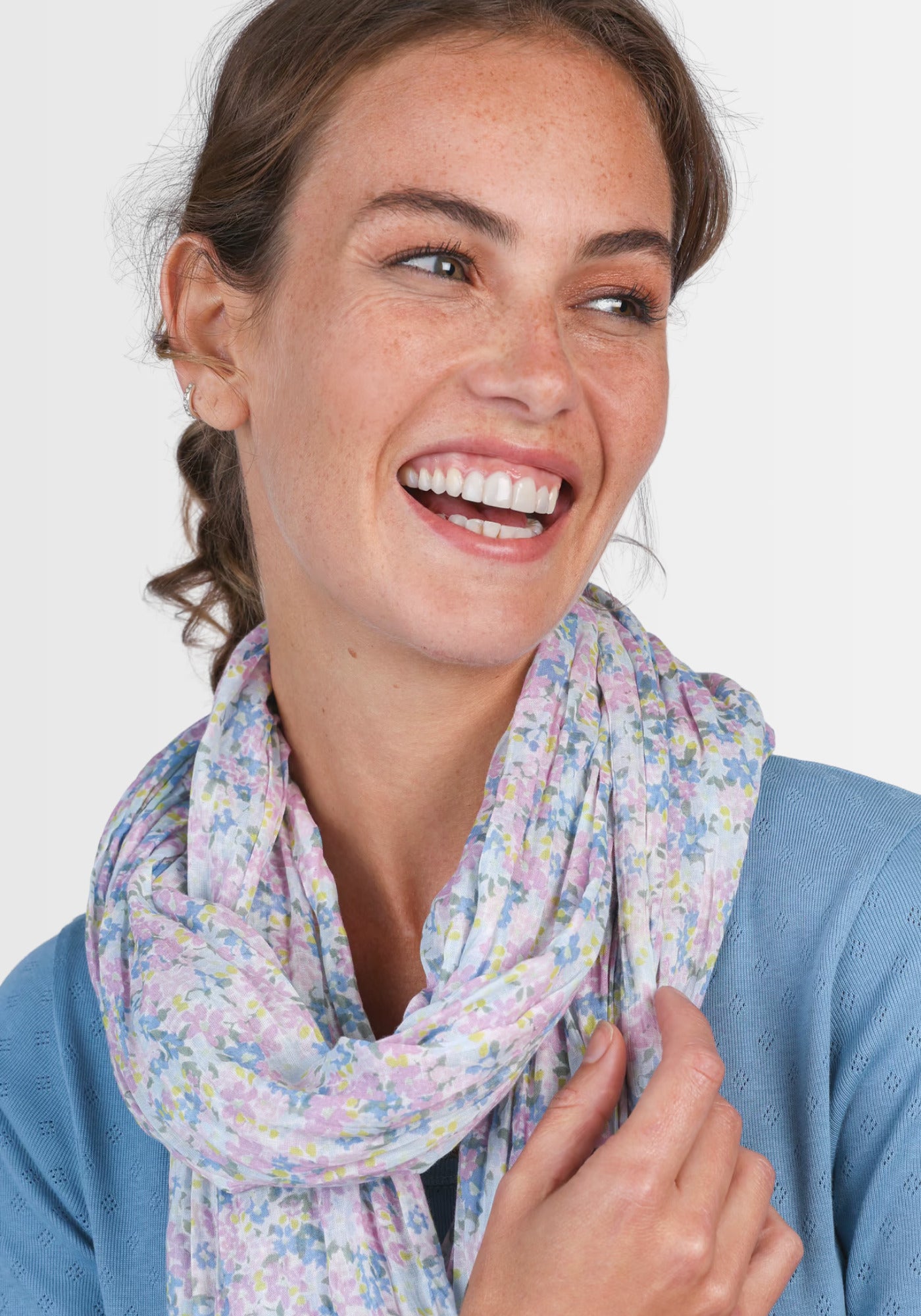 Ein Model trägt das Tuch „Inesse – light blue“ als modisches Highlight. Der atmungsaktive Bio-Baumwollschal besticht durch seinen dezenten floral bedruckten Look und die frischen Blautöne, die jedem Outfit Eleganz verleihen.