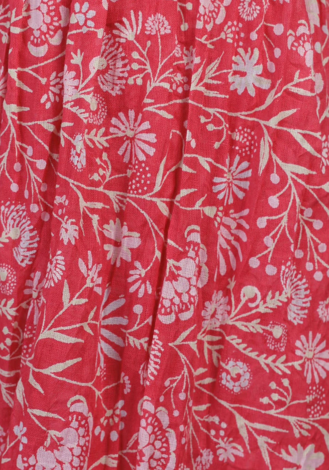 Detailaufnahme des weichen Baumwollschals „Lorie – magnolie“ in Rot, die die feine Stoffstruktur und den harmonischen, floral bedruckten Look hervorhebt – ein Zeichen erstklassiger Verarbeitung.