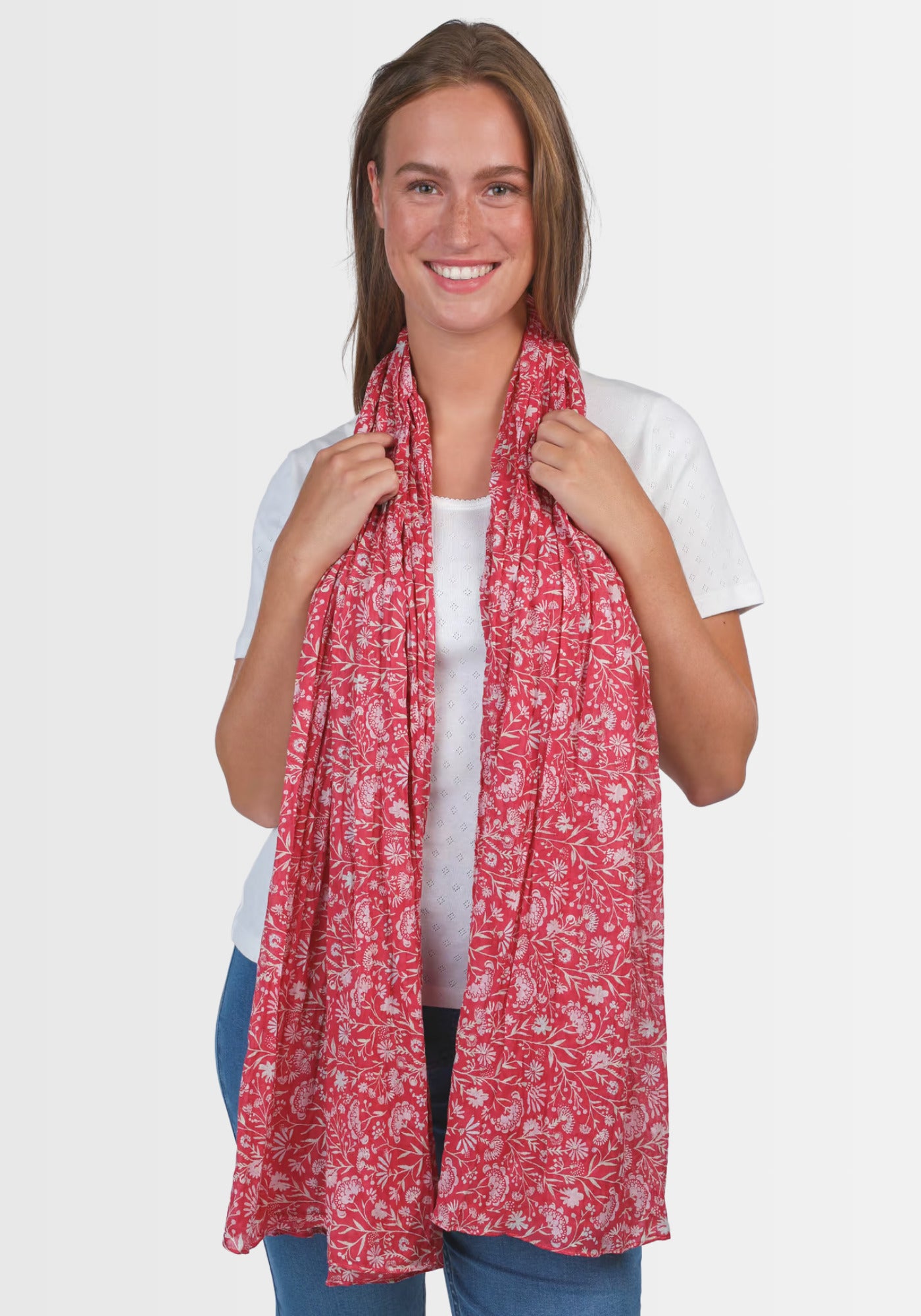 Lifestyle-Aufnahme des Tuchs „Lorie – magnolie“ in Rot, getragen als modisches Highlight. Der exklusive, florale Druck und die weiche Baumwollstruktur machen den Schal zum perfekten Begleiter für elegante Looks.