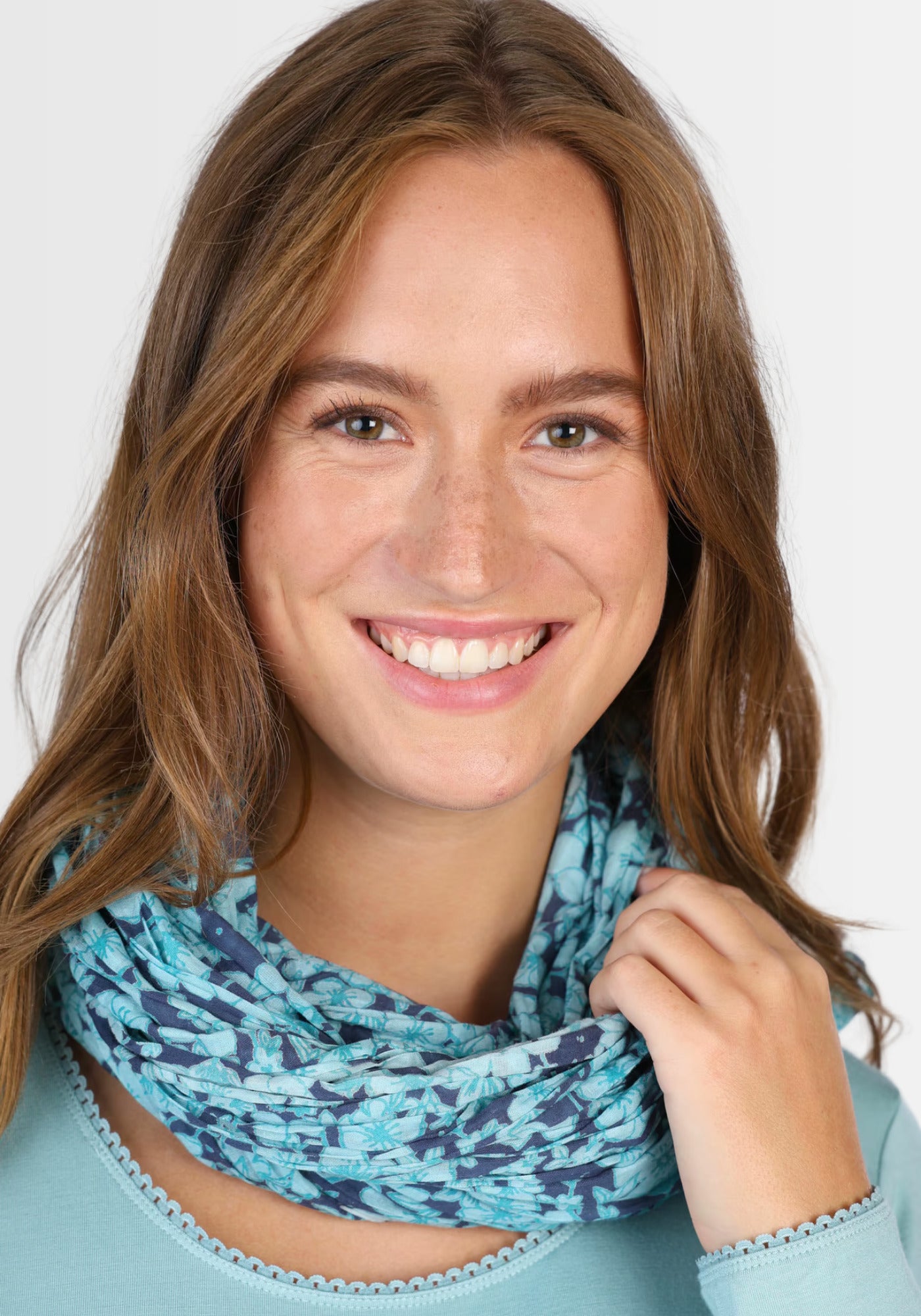 Ein Model trägt das Tuch "Nawel – navy" in einem modernen Outfit. Der Bio-Baumwollschal überzeugt durch seine weiche Haptik und den exklusiven Druck, der jedem Look einen eleganten Akzent verleiht.