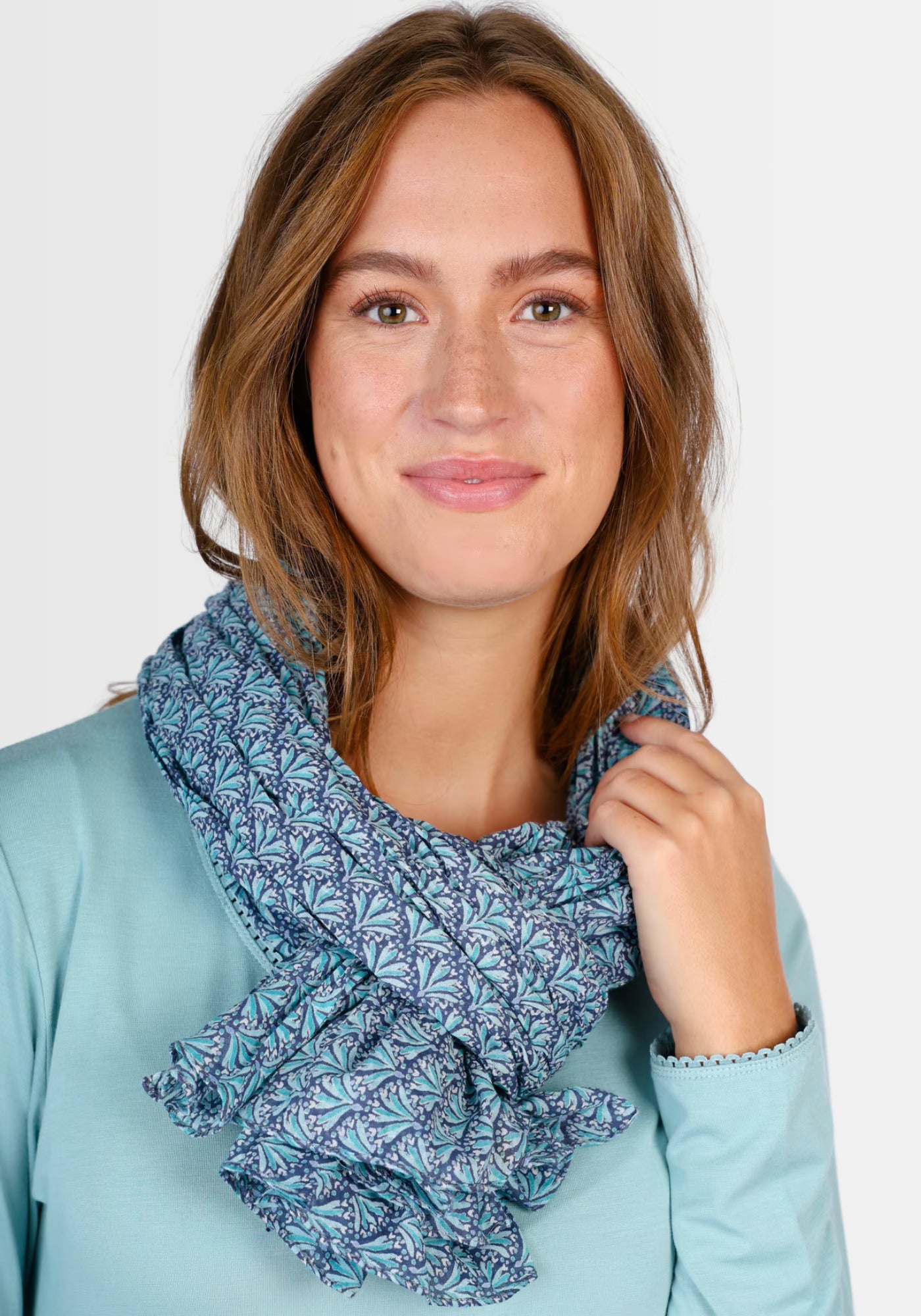 Ein Model trägt das Tuch „Riva“ in Navy von Sorgenfri Sylt. Der elegante Schal besticht durch seinen exklusiven Druck und die angenehme Baumwollqualität – perfekt kombinierbar zu Kleidern und Röcken.