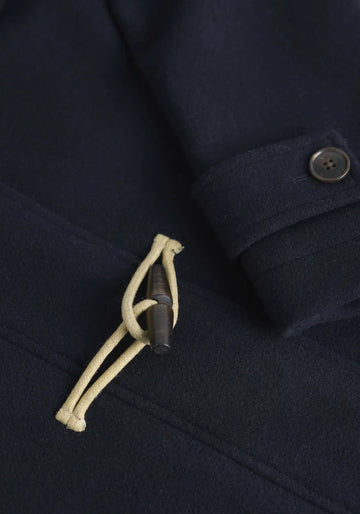 Mit dem Cardinham Duffle Mantel in Blau bleibst du warm und modisch. Recycelter Wollmix, Kapuze und Holzknöpfe machen ihn zum Must-have für die kalte Jahreszeit.

