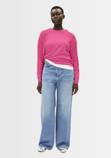 Model zeigt den Larunaa Sweater in Crushed Berry, gefertigt aus 50% Bio-Baumwolle und 50% TENCEL™ Lyocell, mit rundem Halsausschnitt und lockerem Schnitt für einen bequemen, femininen Look.
