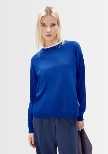 Model trägt den Larunaa Sweater in lapis blue, gefertigt aus 50 % Bio-Baumwolle und 50 % TENCEL™ Lyocell, mit lockerem Schnitt und rundem Halsausschnitt – ideal für einen entspannten Alltagslook.