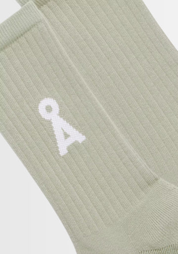 Nahaufnahme der SAAMUS BOLD Socken in „seagreen“, gefertigt aus 78% Bio-Baumwolle, 20% recyceltem Polyamid und 2% Elasthan. Das auffällige A‑Logo unterstreicht den modernen Look, während GOTS-Zertifizierung und PETA-approved vegan für nachhaltige Qualität stehen.