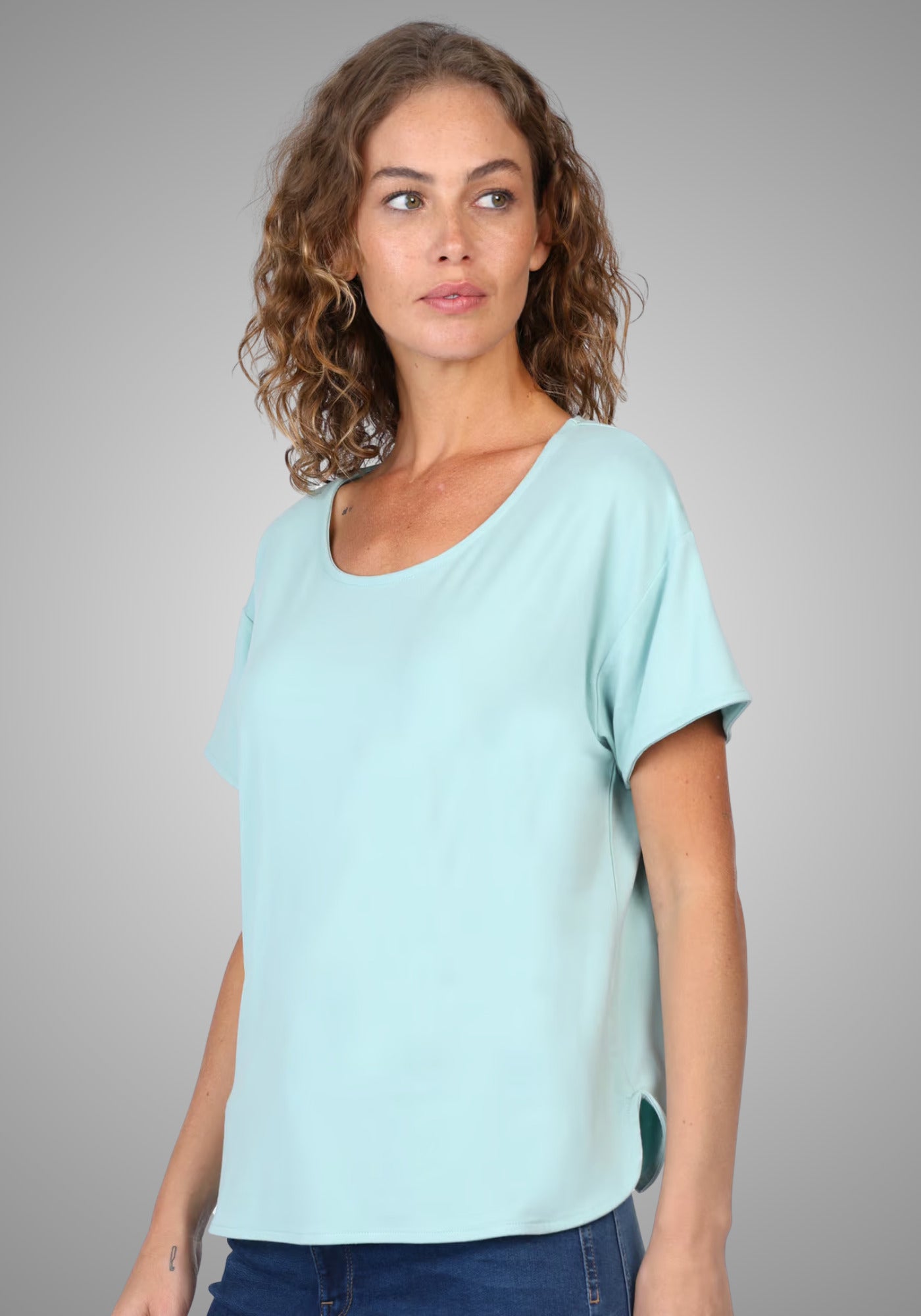 Seitenansicht des T-Shirts "Betzi" in Turquoise, die den lockeren Schnitt und die kurzen Ärmel hervorhebt – perfekt kombinierbar mit Jeans oder Rock für einen entspannten Alltagslook.