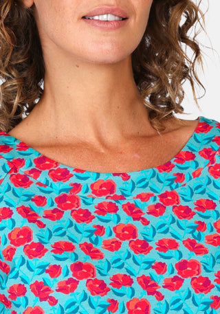 Nahaufnahme des sanften U-Boot-Ausschnitts beim Shirt „Zoe rosy“ in Türkis. Das nachhaltige LENZING™ ECOVERO™-Material betont den weichen Fall und verleiht dem Design einen sommerlichen Charme.

