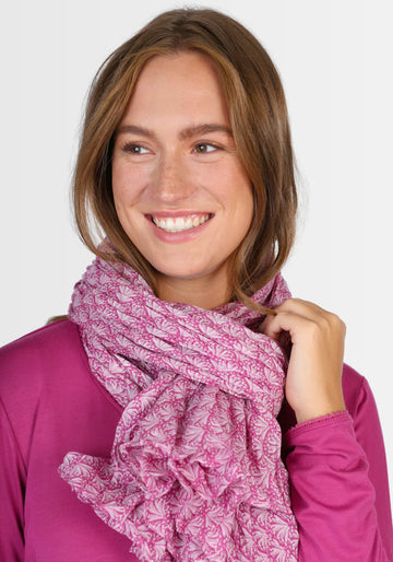 Ein Model präsentiert den Tuch „Riva – raspberry“ von Sorgenfri Sylt. Der weiche, atmungsaktive Bio-Baumwollschal besticht durch seinen lebendigen Farbverlauf und exklusiven Druck – ideal kombinierbar zu Kleidern und Röcken.